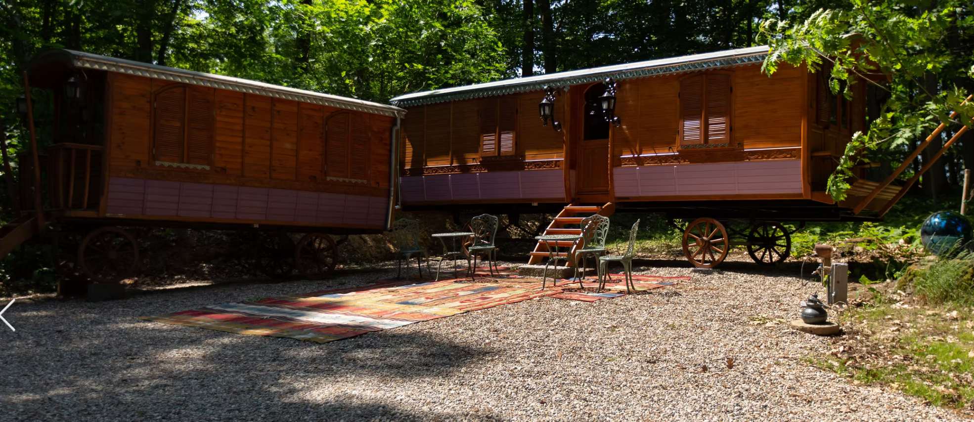 Moderne houten woning met balkon, grote ramen en bomen rondom.