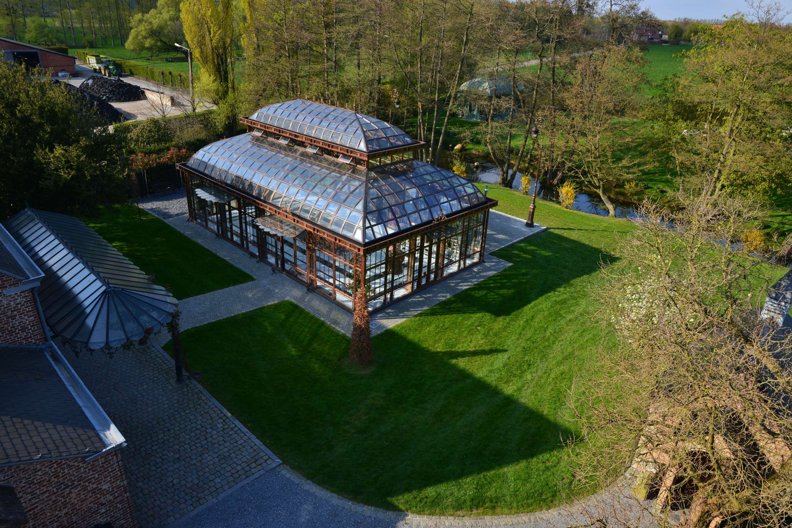 Houten pad met zonne-lampjes naar een prieel in een tuin bij schemering.